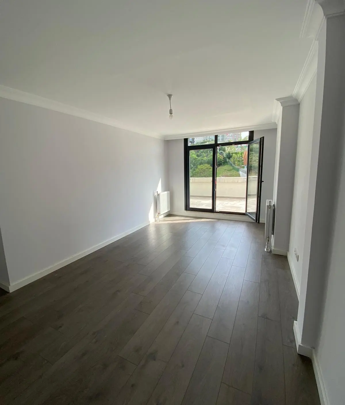 Bright and spacious modern living room with large windows and contemporary interior design in a Bomonti apartment, Istanbul.