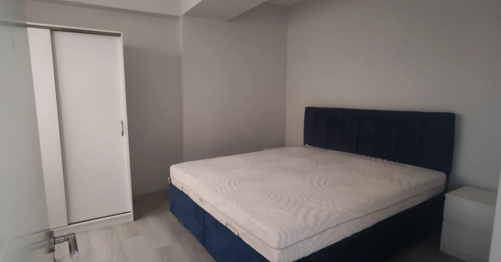 Cozy and modern bedroom interior with warm lighting and elegant decor in a Kurtuluş apartment, Istanbul.