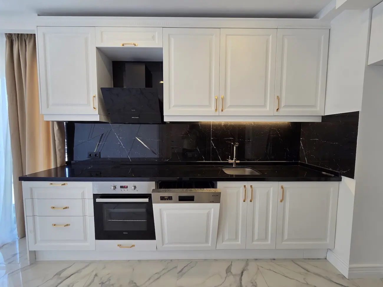 Modern open-plan kitchen area with high-end appliances and sleek cabinetry in a Kağıthane real estate project, Istanbul.